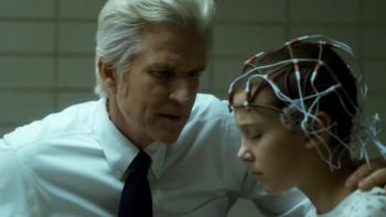  Stranger Things TV show screenshot 3: Dr. Brenner and Eleven sit close together in Hawkins Lab; Eleven's head is covered with wires