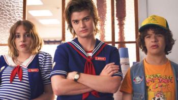 Stranger Things 3 TV show screenshot 2: Robin and Steve are in their Scoops uniform, standing with Dustin in the parlor