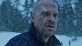 Stranger Things Season 4 screenshot 3: Hopper wears a thick jacket and stands in front of a snowy scene with a patch of snow and a dazed expression