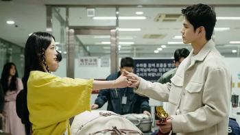 Lee Yoo-mi as Nam-soon and Seong-wu Ong as Kang-Hee-sik, holding hands in promise at a police station.