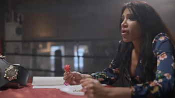 Superhot: The Spicy World of Pepper People screenshot 3: UK champion Shahini Waseem eats a hot pepper next to winner's belt.