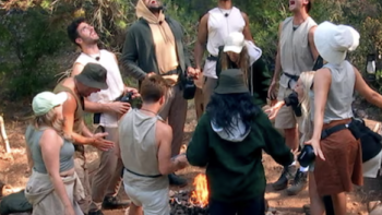 Surviving Paradise TV show screenshot 4: Outsiders stand around campfire. 