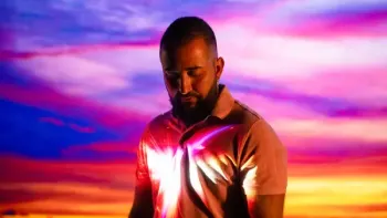 Surviving the Jehovah's Witnesses TV show screenshot: A man looks down, with a colorful backdrop behind him