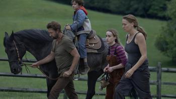 Teacup TV show screenshot 1: The Chenoweth family walks alongside a fence, outdoors on their farm. Three are on foot, while Arlo sits atop a horse.
