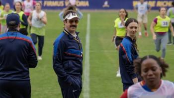Ted Lasso Season 4: Ted and Alice stand on a chaotic football pitch, as players jog around them