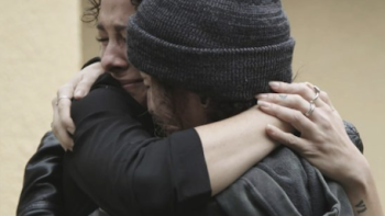 Teen Torture, Inc. TV show screenshot 2: Jen Robison in black hat hugs other survivor.