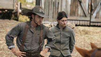 The Abandons TV show screenshot 3: Nick Robinson and Diane Silvers. Robinson wears a dark hat, brown suspenders, and grey shirt.