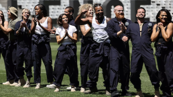 The Challenge: World Championship: Legends wear black and white and smile and clap on stadium field. 