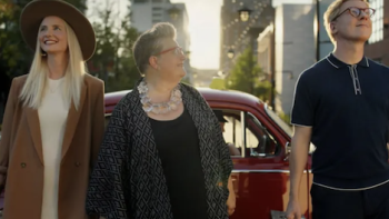 The Gentle Art of Swedish Death Cleaning screenshot 1: Kat Ella, and Johan stand on U.S street in front of red taxi staring at sky. 