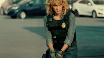 The Gringo Hunters TV show screenshot 2: Officer Gloria Carbajal in police vest holds gun. 