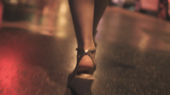 The Hillside Strangler TV show screenshot 1: A woman's legs wearing sandal wedges shown walking on Hollywood stars on sidewalk.