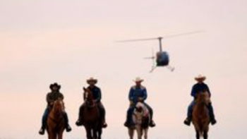 The McBee Dynasty screenshot 3: Silhouettes of four people on horseback and a flying helicopter. 