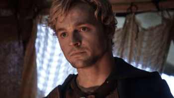 The Pendragon Cycle: Rise of the Merlin TV show screenshot 1: Taliesin with blonde hair in medieval attire looks serious indoors.