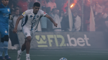 The Root of the Game TV show screenshot 1: Soccer player in white kicks ball on a smoky field.