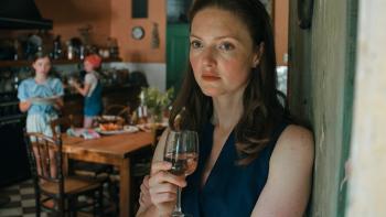 The Stolen Girl TV show screenshot 3: Holliday Grainger leans against a door frame while holding a glass of white wine.
