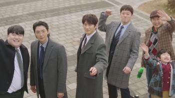 The Apartment Job TV show screenshot: Five Korean men and a child in coats, smiling and waving outdoors on a stone path.