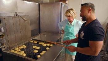 The Big Bakeover: A white woman watches as a Cambodian man fries donuts