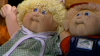 The_Toys_That_Built_America_ss1: Close up of a boy and girl Cabbage Patch Kid doll side by side.