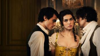 The Seduction TV show screenshot 1: A young woman in a gold corset dress stares ahead while two dark haired men in period piece clothing lean into her
