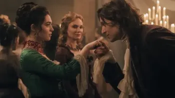 The Seduction TV show screenshot 2: A dark haired woman in a green ball gown has her hand kissed by a man in a coat and frills at a ball