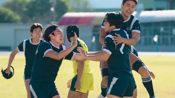 The Winning Try TV show screenshot 1: Rugby players jump toward each other, high-fiving and celebrating out the field in bright sunlight