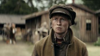 To Cook a Bear TV show screenshot 2: A young blond man in layers of Sami and old Swedish clothing stands with dirty face looking troubled off camera.