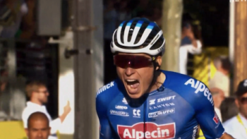 Tour de France: Unchained TV show screenshot 1: A cyclist in blue and red from Alpecin-Deceunick celebrates crossing a stage finish. 