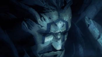 Ubel Blatt TV Show: A darkly lit older man with a design painted on his face looks down seriously. 