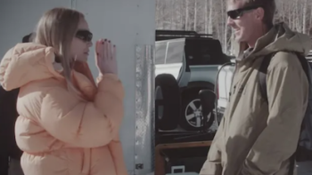 Unwell Winter Games TV show screenshot 1: Alex Cooper talks to a production staff member wearing a brown jacket..