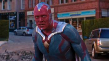 VisionQuest: In his Red Vision skin and Avengers uniform, Vision stares at something dismaying off-screen on a commercial city block