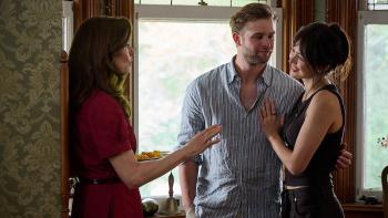 Vladimir TV show screenshot 3: Our main character holds a plate of food while Vladimir and Cynthia stand talking with her, arms around each other