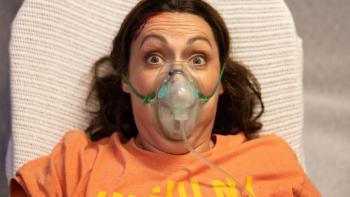 Wellmania TV show: Liv is shown in closeup with an oxygen mask on her face, looking panicked