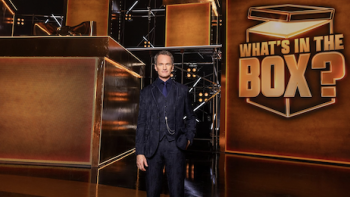 What's in the Box TV show screenshot 2: Neil Patrick Hararis stands next to large gold boxes and show logo. 