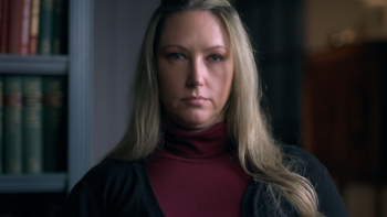 Worst Neighbor Ever screenshot 1: Serious woman with long blonde hair wearing a red turtleneck and black cardigan.