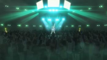 Ya Boy Kongming!: Eiko on stage performs for a large crowd, the stage and room filled with green and white light.