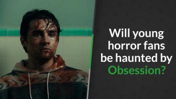 A battered, bloodied man in a patterned hoodie stares blankly in a tiled bathroom/