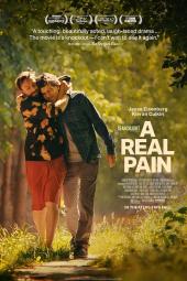 A Real Pain movie poster: Kieran Culkin hugs Jesse Eisenberg while walking on a trail in the trees