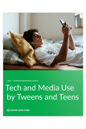 Boy lying down with earbuds in looking at mobile phone