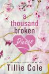 A Thousand Broken Pieces book cover: Gold strands run through pink background with scattered cherry blossoms around title