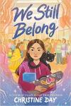 We Still Belong book cover: Native American girl with a cat on her shoulder standing in a crowded room