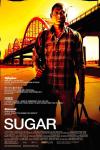 Sugar movie poster: Algenis Perez Soto stands holding a duffle bag on his shoulder in front of a bridge at sunset