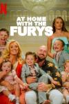 At Home with the Furys TV show poster: World Heavy Weight Champion boxer, Tyson Fury, sits in his grand living room with his wife and 6 children smiling at the camera.