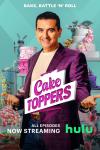 Cake Toppers: Budy Valastros stands in front of a baking shelf full of cakes while smiling and wearing a purple blazer.