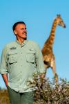 Wild World (Mundo Salvaje) with Ron Magill: Ron Magill and a giraffe in the back.