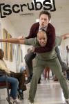 Scrubs TV show poster: J.D. and Turk are shown in a hospital corridor, doing their piggyback "Eagle" position
