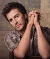 It's All Country: The host of the show sits with his hands interlocked.